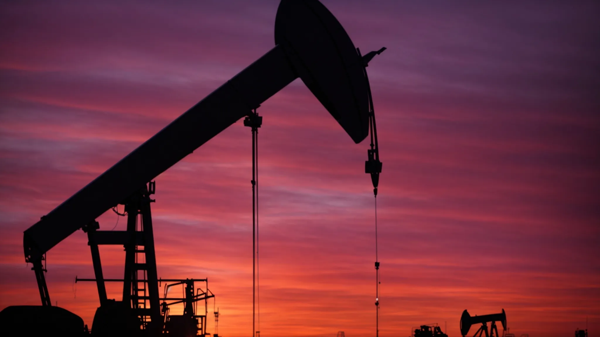 oil pumps silhouette against a vivid sunset, symbolizing the volatile world of transboundary oil resource management.