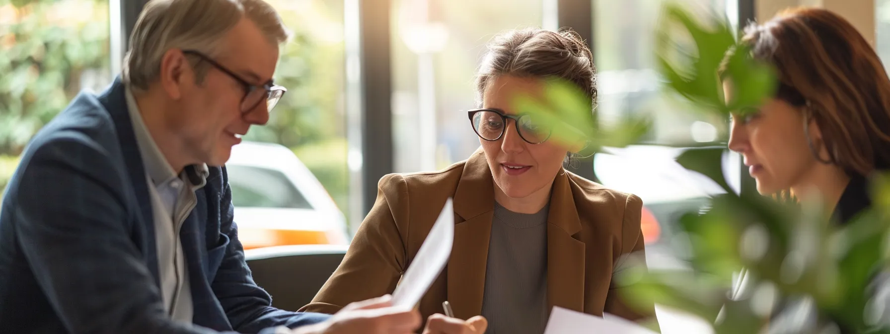 three professionals discussing legal documents and plans in an office setting.